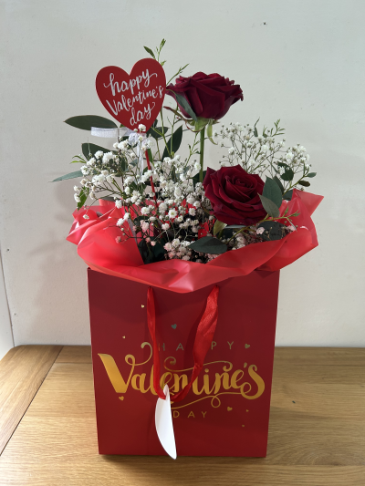Valentines Gift Bag - A fresh flower arrangement presented in a Valentines themed gift bag.